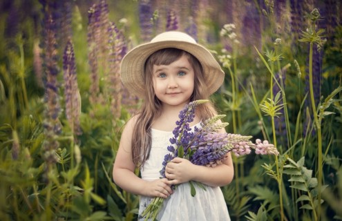 Caucasian girl holding bouquet of wildflowers