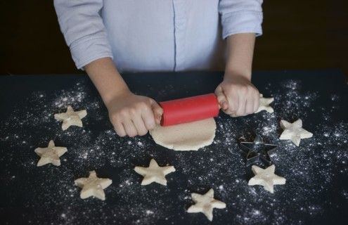 Caucasian boy rolling cookie dough