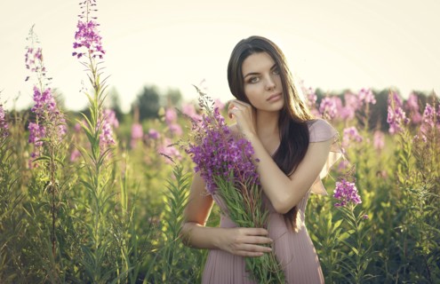 Portrait of Caucasian woman gathering wildflowers in field