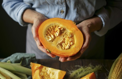 Hands of Caucasian woman showing sliced squash