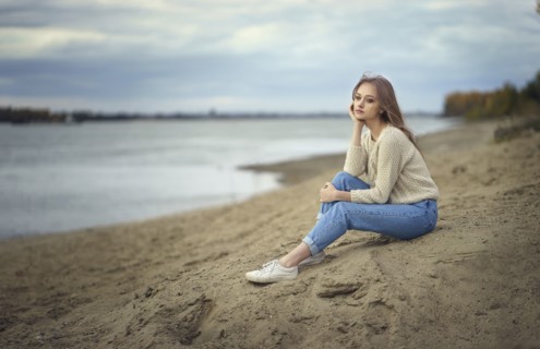 Pensive woman sitting on beach