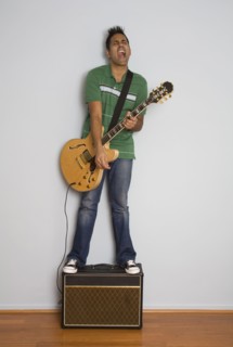 Mixed race man playing electric guitar