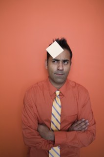 Mixed race businessman with sticky note on forehead