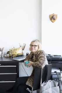 Caucasian woman drinking coffee at desk with laptop