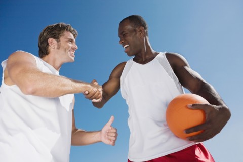 Multi-ethnic men with volleyball shaking hands