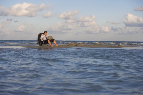 Hispanic businessman on sandbar