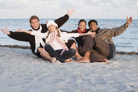 Multi-ethnic couples sitting on beach