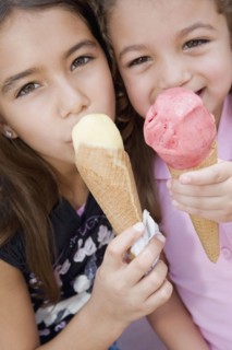 Hispanic sisters eating ice cream cones