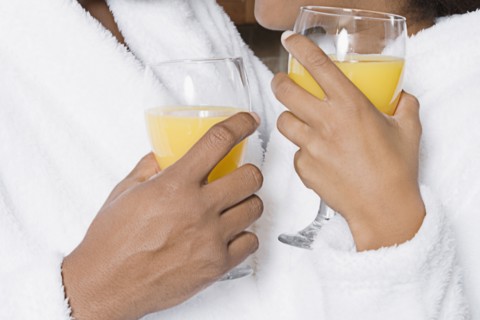 African couple holding orange juice