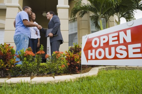 African couple shaking hands with Hispanic real estate agent