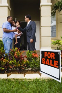 Hispanic real estate agent giving house keys to African family