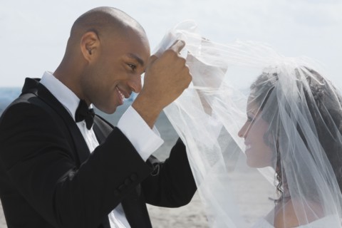 African groom lifting bride's veil