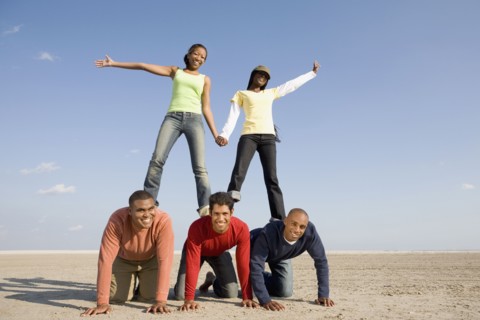 Multi-ethnic friends making human pyramid
