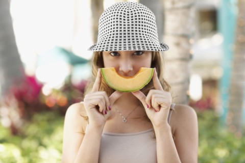 Hispanic woman holding melon slice