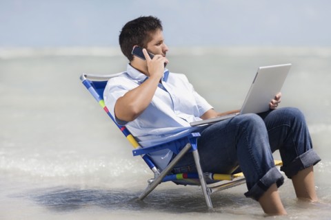 Hispanic man in beach chair with laptop
