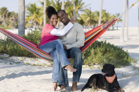 Hispanic couple hugging in hammock
