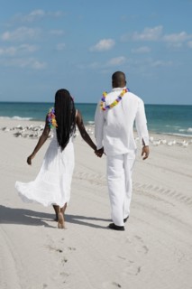 African couple holding hands at beach