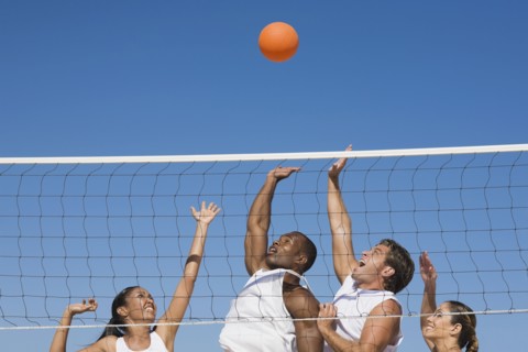 Multi-ethnic friends playing volleyball