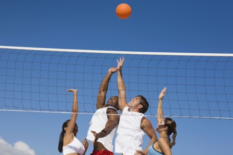 Multi-ethnic friends playing volleyball