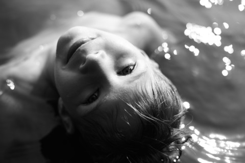 Caucasian boy swimming in water