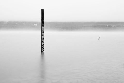 Wooden measuring post in water