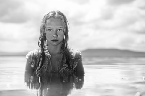 Caucasian teenage girl swimming in lake