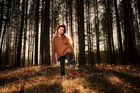 Caucasian girl playing in forest