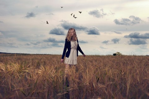 Caucasian teenage girl standing in field of tall grass