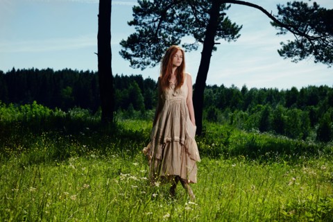 Caucasian woman standing in grass on rural hill
