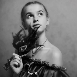 Caucasian girl holding feather mask