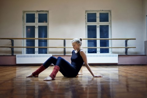Caucasian dancer sitting on studio floor