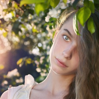 Caucasian teenage girl standing under tree