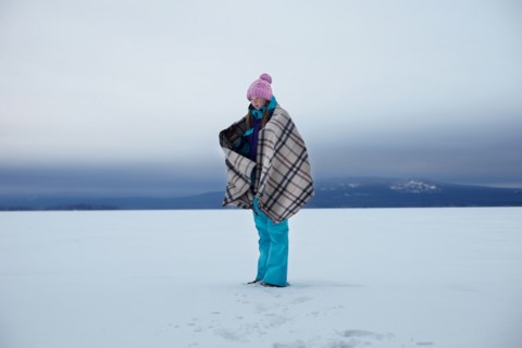 Caucasian teenage girl wrapped in blanket in snow