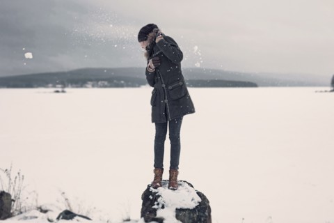 Caucasian teenage girl dodging snowballs