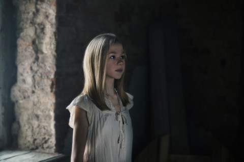 Caucasian girl standing at window