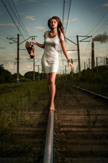 Caucasian woman balancing on train tracks
