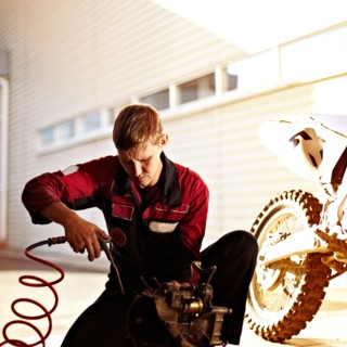 Caucasian mechanic examining motorcycle parts