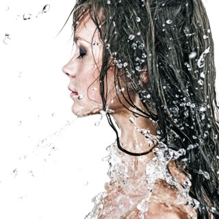 Face of Caucasian girl splashing in water