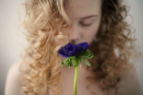 Caucasian teenage girl smelling flower