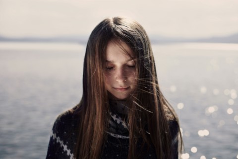 Pensive Caucasian girl at lake