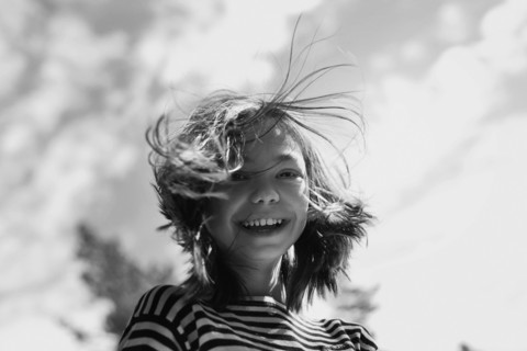 Smiling Caucasian girl with hair blowing in wind