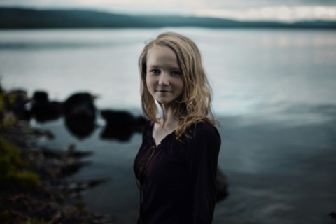 Smiling Caucasian girl standing at lake