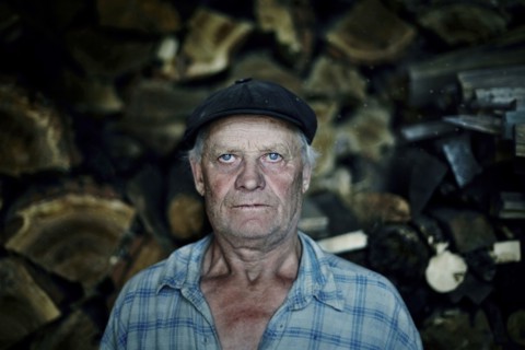 Serious Caucasian man near woodpile