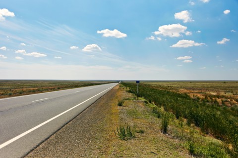 Distant empty highway under blue sky