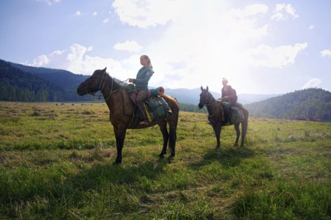 Caucasian girls riding horses in field