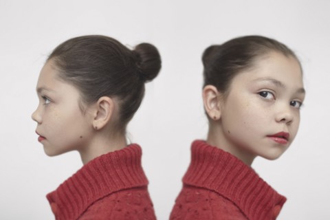 Twin Caucasian girls wearing red sweater