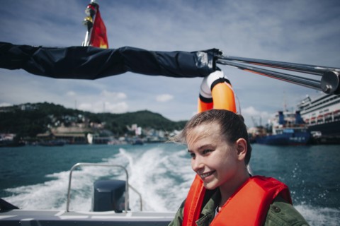 Caucasian woman wearing life-jacket in speedboat