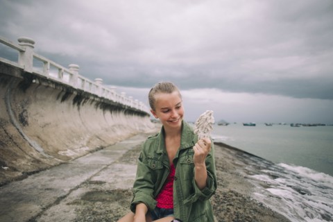 Caucasian woman holding shell at beach