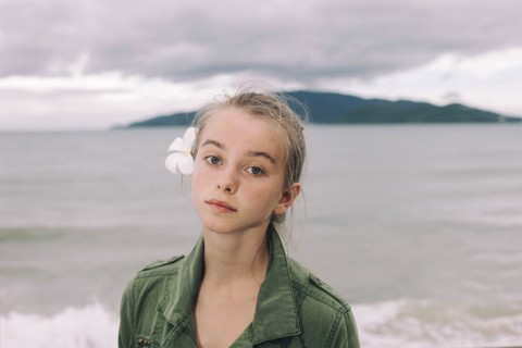 Caucasian woman with flower in hair near ocean