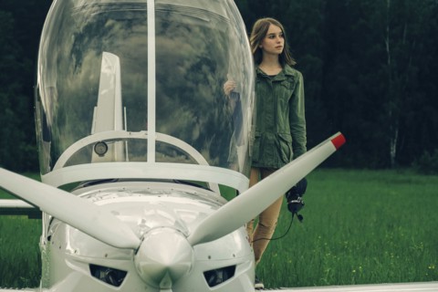 Caucasian woman standing near an airplane cockpit